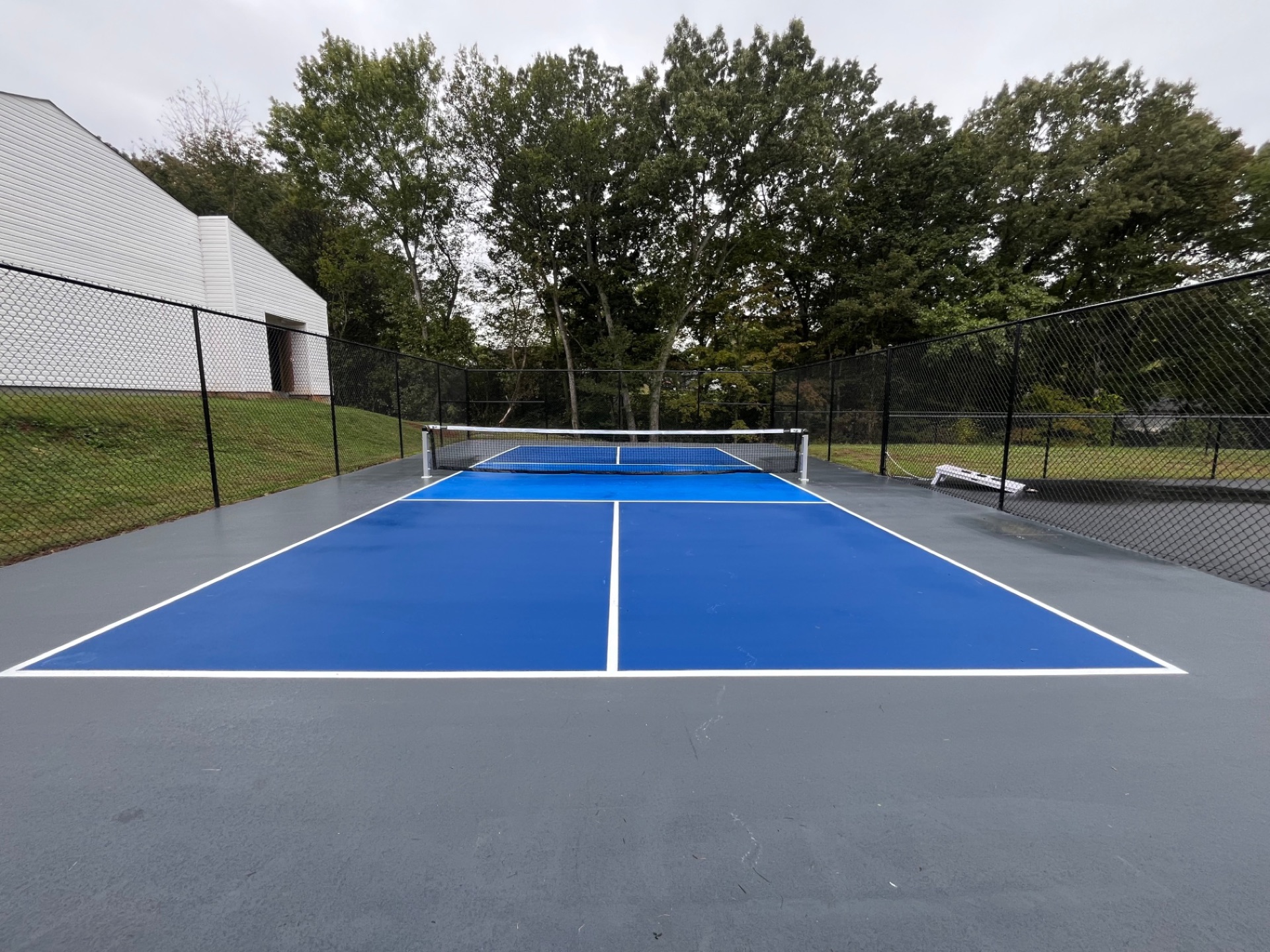 New pickleball court installation with fresh blue surface and white lines