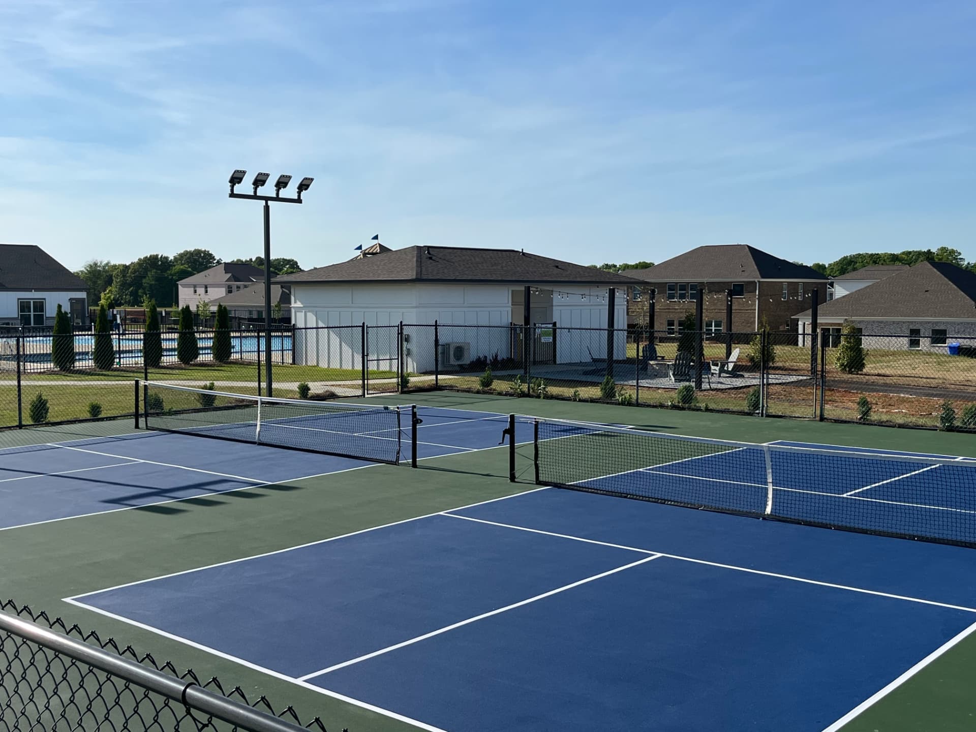 Community pickleball complex with blue courts and green surrounds