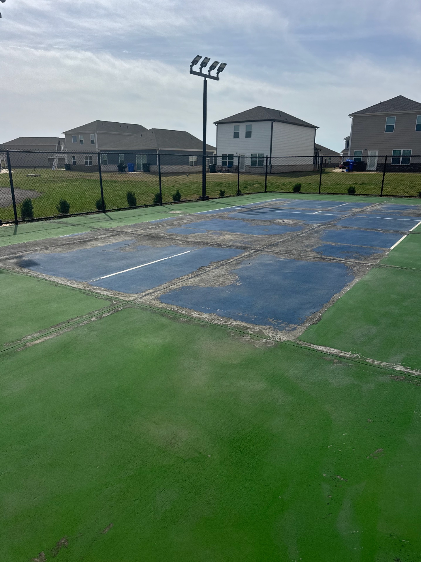 Worn commercial pickleball courts before repair