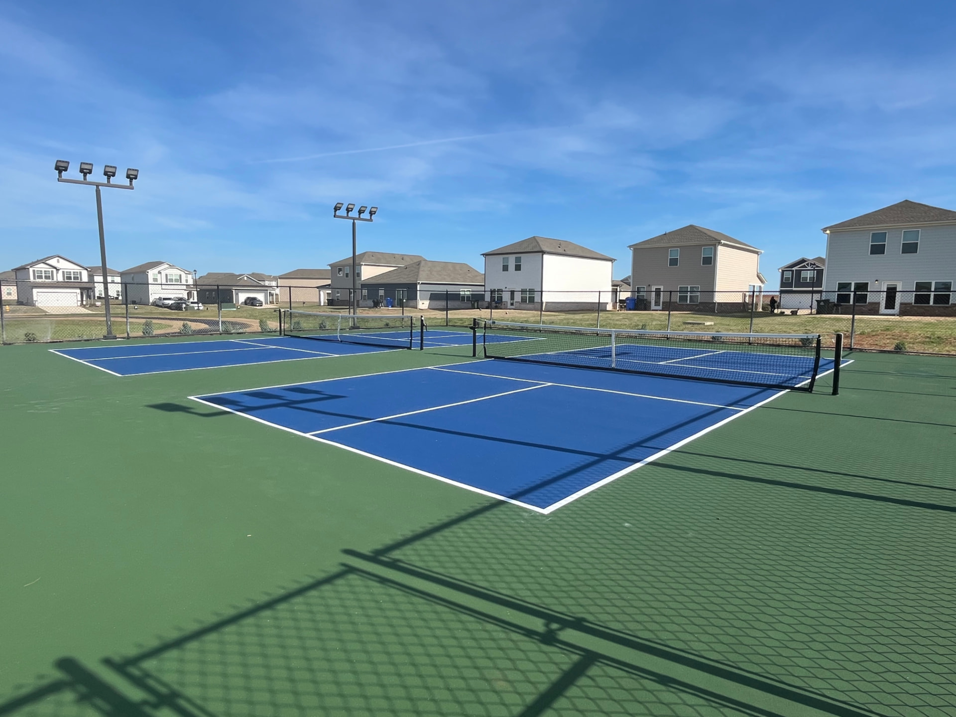 Resurfaced blue and green pickleball courts after repair